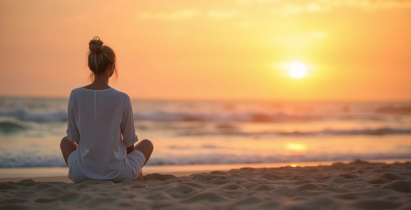 Meditierende Person am Strand bei Sonnenuntergang in entspannter Pose